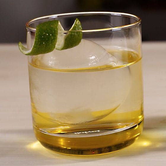 Clarified THC cocktail served crystal clear over a clear ice sphere with a lime twist